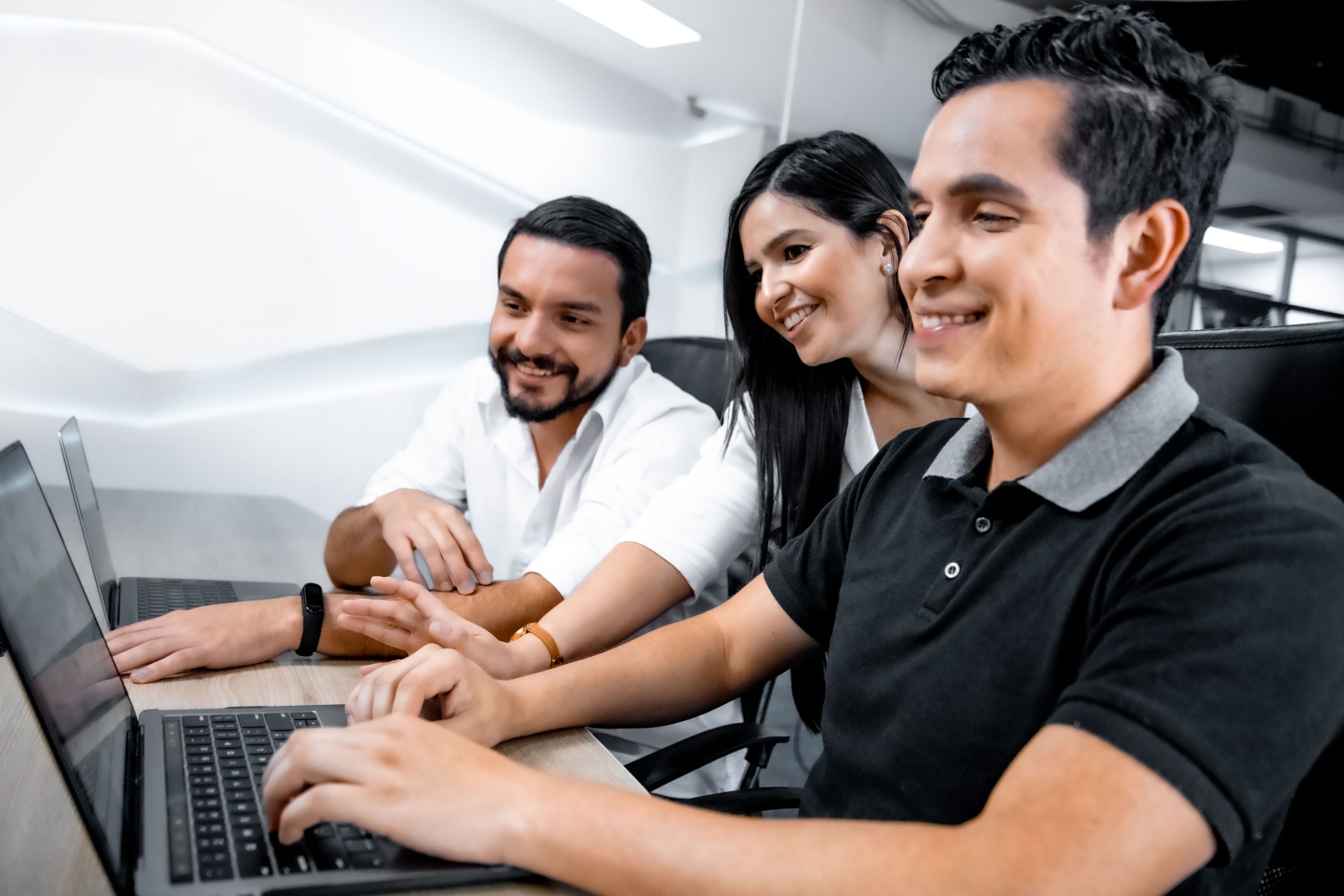 Three collaborators from Dnamic working with two laptops