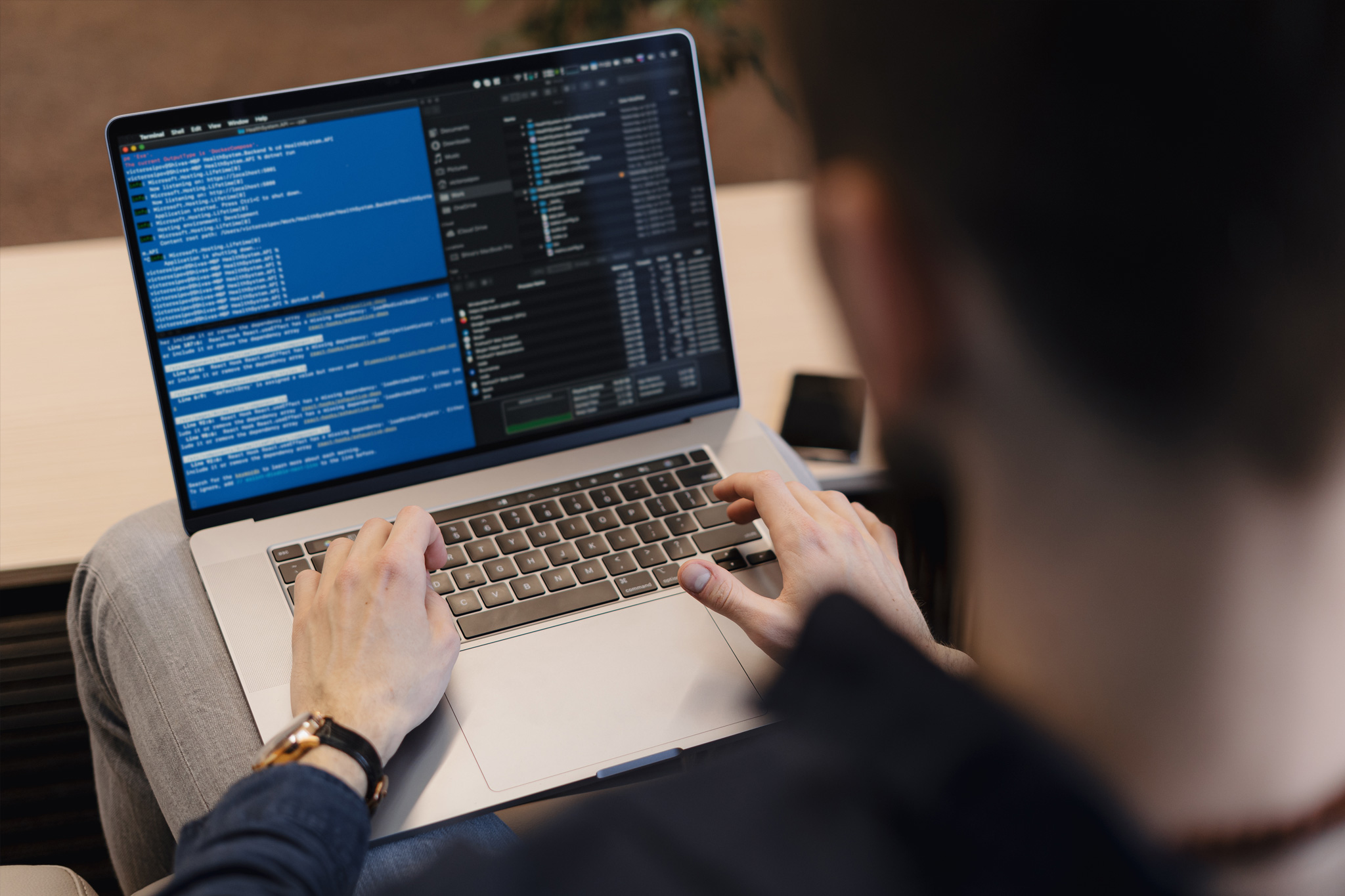 Back view of a software developer working on his computer